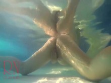 Nena elegante y flexible nadando bajo el agua en la piscina al aire libre. 3 1