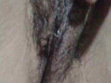 Chica con curvas tocando su coño peludo y jugoso